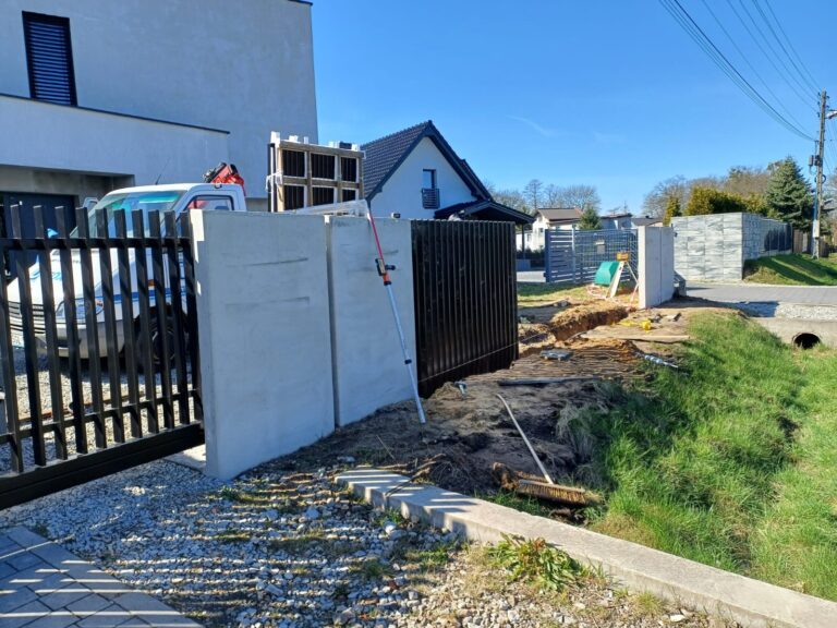 Montaż pionowych przęseł przy betonowych słupach, z niwelatorem i łatą pomiarową